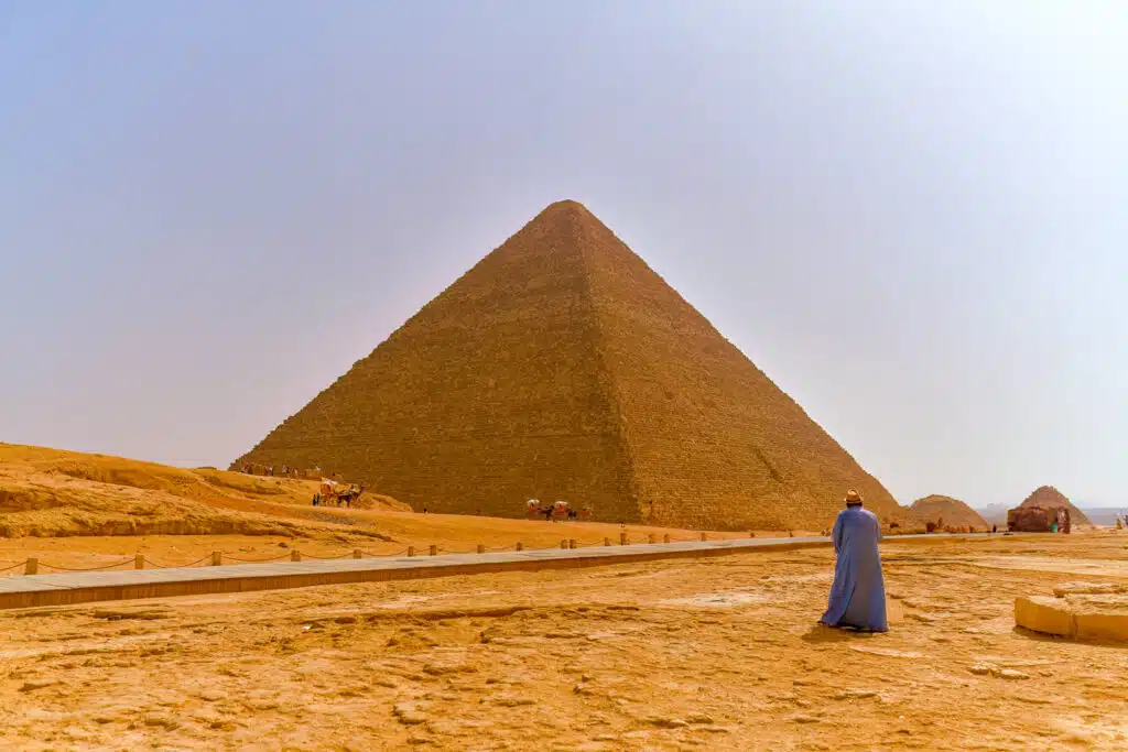 Man standing in front of pyramid in Egypt.